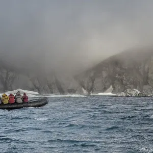 Tourists in an inflatable boat approaching Herald Island