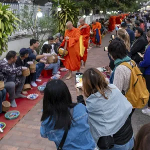 Tourists take pictures of monks during the Morning Alms ceremony Tourists take pictures of monks during the Morning Alms ceremony