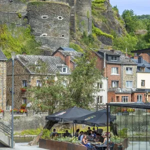 Tourists at restaurant along the river Ourthe and ruined castle in the city La Roche-en-Ardenne Tourists at restaurant along the river Ourthe and ruined castle in the city La Roche-en-Ardenne