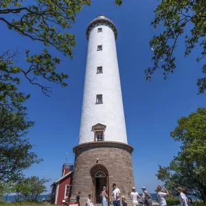 Tourists stand in front of the Lange Erik lighthouse