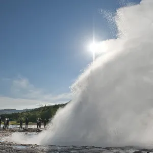 Tourists standing next to the Strokkur geyser
