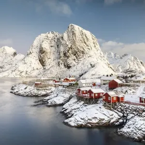 Town and fisherman's cabins or Rorbus in front of snowy mountains