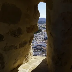 Town of olvera rooftops seen through a dark narrow window in a historic stone castle in olvera Town of olvera rooftops seen through a dark narrow window in a historic stone castle in olvera