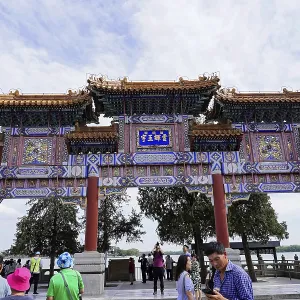 Traditional Chinese gate with ornate architecture and people below Traditional Chinese gate with ornate architecture and people below