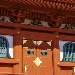 Traditional Japanese temple architecture with red and gold structures and detailed decorations