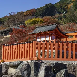 Traditional Japanese temple in a valley surrounded by autumn colors and mountains