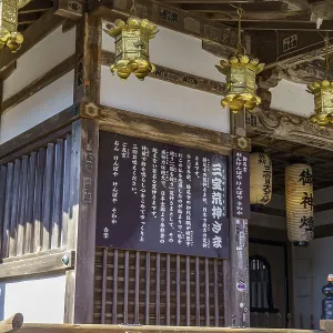 Traditional Japanese temple with wooden details and lanterns on the walls