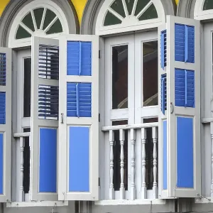 Traditional windows with colorful shutters and colonial architecture Traditional windows with colorful shutters and colonial architecture