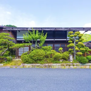 Front of a traditional wooden house with neatly manicured Japanese garden on the Nakasendo route in Tsumago