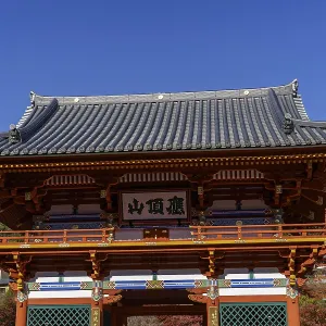 A traditionally designed Japanese temple building against a blue sky