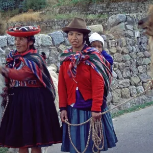 Traditionally dressed woman with llamas and small children in Cusco