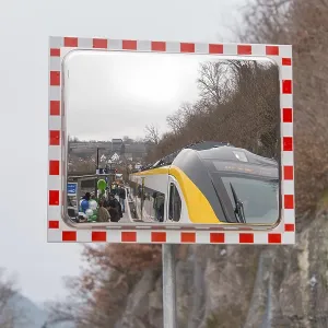 A train in the mirror on a railroad track in a mountainous area