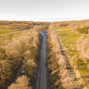Train route from above, flanked by autumnal forests Train route from above, flanked by autumnal forests