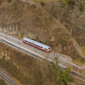 A train travels on a track through wooded hills in a wintry landscape A train travels on a track through wooded hills in a wintry landscape