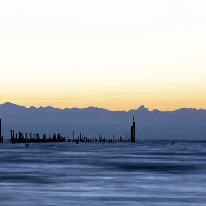 Tranquil evening mood on the lake with mountain silhouettes at sunrise