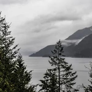 Tranquil lake framed by misty mountains Tranquil lake framed by misty mountains