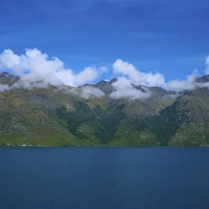 Tranquil landscape with mountains and a deep blue lake under a clear sky