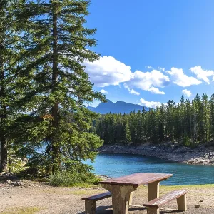 Turquoise waters of lake minnewanka sparkle under a bright blue sky