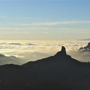 Unique mountain silhouette at sunset over a sea of clouds Unique mountain silhouette at sunset over a sea of clouds