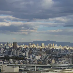 Urban panorama with visible highways and mountains on the horizon under a cloud cover Urban panorama with visible highways and mountains on the horizon under a cloud cover