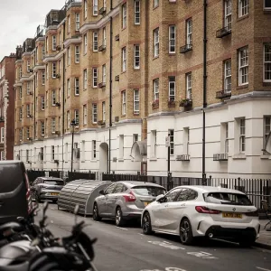 Urban street lined with parked cars and residential buildings in Greater London Urban street lined with parked cars and residential buildings in Greater London