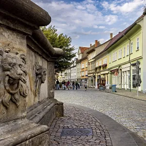 Urban street with lion head sculpture and historic architecture Urban street with lion head sculpture and historic architecture