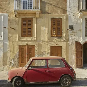 VALLETTA, MALTA - OCTOBER 30, 2017: Old vintage car in front of typical traditional house in Valletta in Malta VALLETTA, MALTA - OCTOBER 30, 2017: Old vintage car in front of typical traditional house in Valletta in Malta