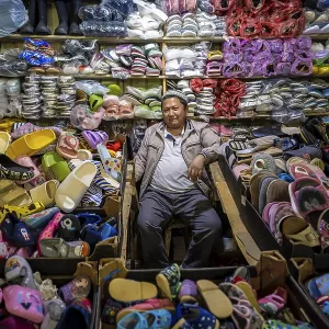 Vendor of shoes in his stall, very many shoes Vendor of shoes in his stall, very many shoes