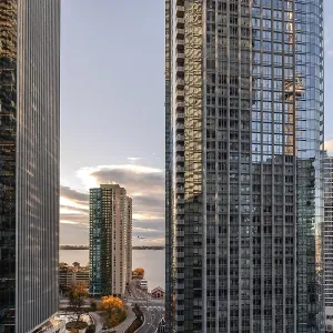 A vibrant cityscape with glass skyscrapers reflecting the sunset and a scenic view
