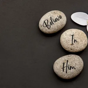 Top view of Believe In Him text engraved on zen stones with additional customizable space for text or messages