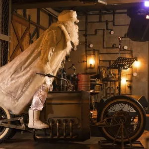 Side view of brutal Santa Claus in white clothes standing on vintage motorbike in grunge rock bar Side view of brutal Santa Claus in white clothes standing on vintage motorbike in grunge rock bar