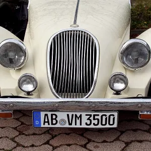 Front view of a classic white classic car with visible number plate