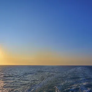 View from the cruise ship at sunrise at the stern of the ship onto the stern waves