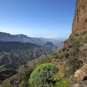 View of a deep valley and distant mountains from a mountain trail View of a deep valley and distant mountains from a mountain trail