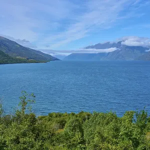 View of a lake framed by mountains and a blue sky