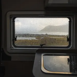 View from rainy campervan kitchen window on Flakstad beach