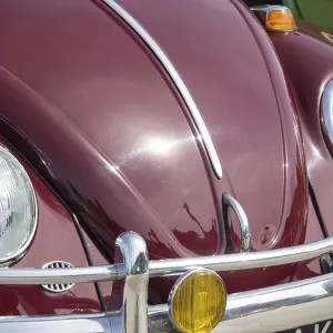 Front view of a red classic car with chrome details and eye-catching headlights Front view of a red classic car with chrome details and eye-catching headlights
