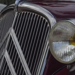 Front view of a red vintage car with striking radiator grille and detailed emblem Front view of a red vintage car with striking radiator grille and detailed emblem