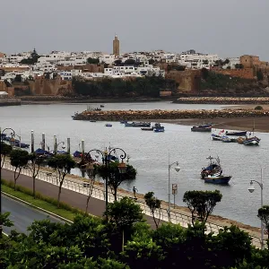 View across the river to the historic town of Sale with boats and city wall under cloudy sky