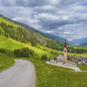 View along a road to the church of Winnebach with the valley behind it View along a road to the church of Winnebach with the valley behind it