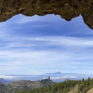 View through a rock arch to Roque Nublo and the Teide mountain peak on the neighbouring island of Tenerife View through a rock arch to Roque Nublo and the Teide mountain peak on the neighbouring island of Tenerife