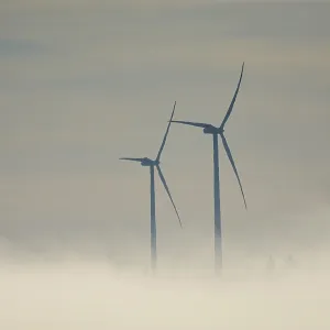 View from Rosengarten-Raibach of fog-shrouded wind turbines in the KohlenstraBe wind farm