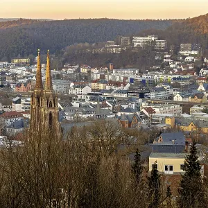 View of a town with a church and surrounding hills at sunset View of a town with a church and surrounding hills at sunset
