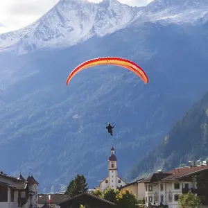 View of town with paraglider, meadow