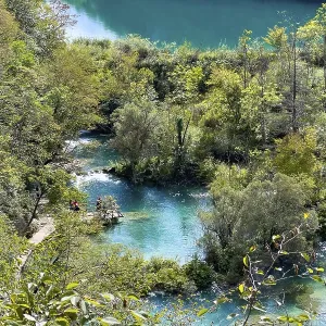 Vue de cascades turquoise avec passerelle en bois.