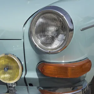 Front view of a turquoise vintage car with additional yellow headlights and chrome details Front view of a turquoise vintage car with additional yellow headlights and chrome details