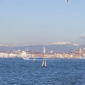 Paisaje panorámico de Venecia desde el Lido con cumbres alpinas cubiertas de nieve en segundo plano Paisaje panorámico de Venecia desde el Lido con cumbres alpinas cubiertas de nieve en segundo plano