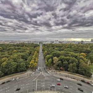 Vue de la colonne de la Victoire, Un ciel nuageux dramatique sur Berlin avec une longue avenue bordée d'arbres d'automne.