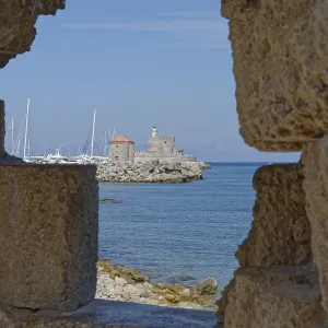 View through a wall of a medieval fort of Saint Nikolaos by the sea with sailing boats