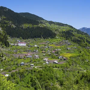 Villages nestled in a green mountain landscape with blue sky